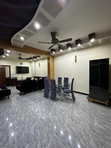 a conference room with a table and chairs and a screen at HHH Brothers House in Rawalpindi