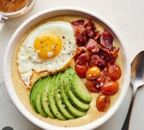 a bowl of food with an egg and avocado and pickles at Herdade de Santa Maria in Almeirim
