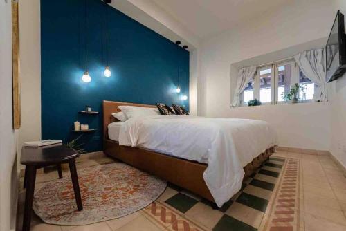 um quarto com uma cama grande e uma parede azul em LUXURY Mid-Century Apartment In Casco Viejo na Cidade do Panamá