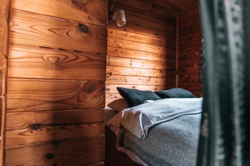 1 dormitorio con paredes de madera y 1 cama en una habitación en Kaldbaks-kot cottages, en Húsavík