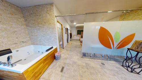 Hotel Villa Colonia في مارينيلا: حمام كبير مع حوض في الغرفة
