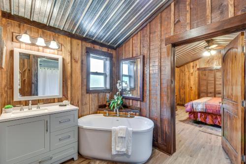 a bathroom with a tub and a sink and a bed at Clarkesville Rustic Hideaway on 38-Acre Farm! in Clarkesville