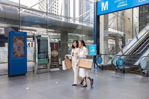 two women walking through a shopping mall at Four Points by Sheraton Bangkok, Sukhumvit 15 in Bangkok