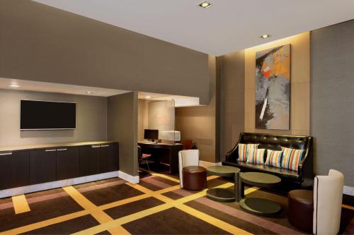 a living room with a couch and a tv at Four Points by Sheraton Bangkok, Sukhumvit 15 in Bangkok