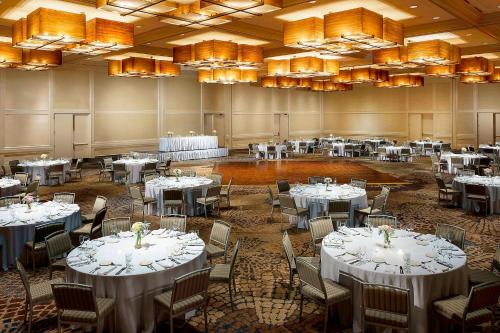 a banquet hall with white tables and chairs and chandeliers at The Westin Chicago Northwest in Itasca