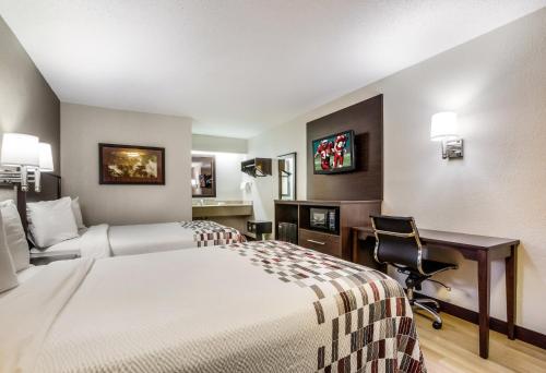 a hotel room with two beds and a desk at Red Roof Inn Lexington in Lexington