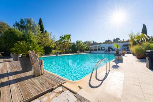 una piscina con un banco de madera al lado en DOMAINE DE LA SOURCO - Villa, Maisons & Chalet, Magnifique Havre De Paix En Provence en Trans-en-Provence