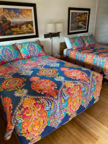a hotel room with a bed and a bedspread on it at Starlight Motel in Big Pine