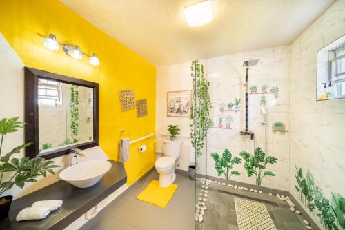 a bathroom with a shower and a toilet and a sink at Hidden Gem Barbados in Christ Church