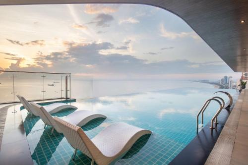 a pool with chairs and a view of the city at Radisson Hotel Danang in Danang