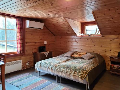 a bedroom with a bed in a wooden cabin at Villa Jääskelä Hanko - koko talo in Hanko