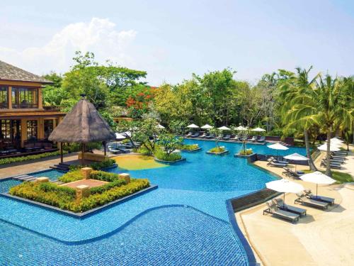 uma piscina num resort com cadeiras e guarda-sóis em Mövenpick Asara Resort & Spa Hua Hin em Hua Hin