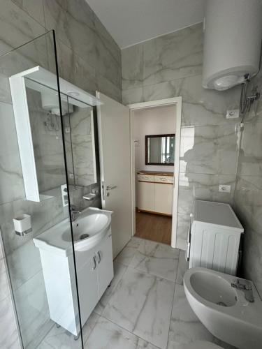 y baño con lavabo, aseo y espejo. en Shehu’s Apartament en Tirana