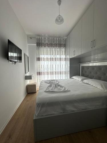 Un dormitorio con una cama grande y una ventana en Shehu’s Apartament en Tirana