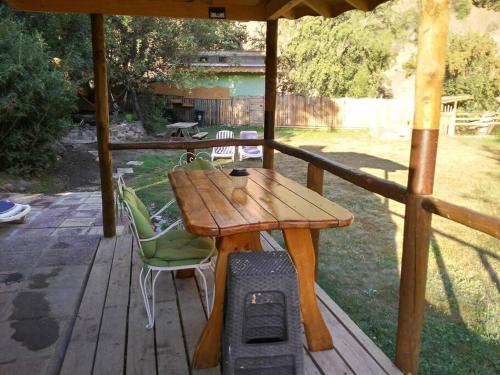 einen Holztisch und Stühle auf einer Holzterrasse in der Unterkunft ammonite aventura del Maipo casa entera reserva 50 por ciento anticipado in San José de Maipo