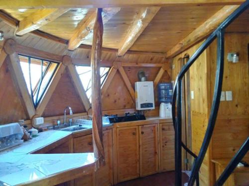 a kitchen with wooden cabinets and a large window at ammonite aventura del Maipo casa entera reserva 50 por ciento anticipado in San José de Maipo