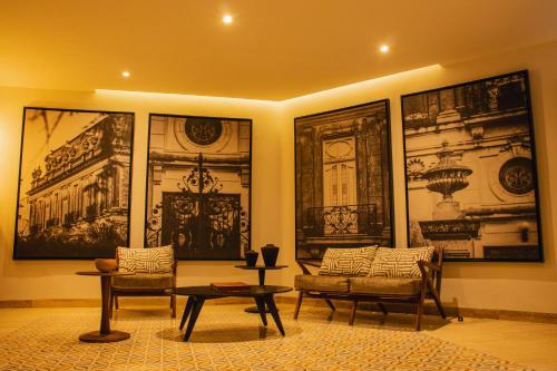 a living room with two chairs and a table at Casa Continental Hotel Boutique & Suites - Adults Only in Mérida