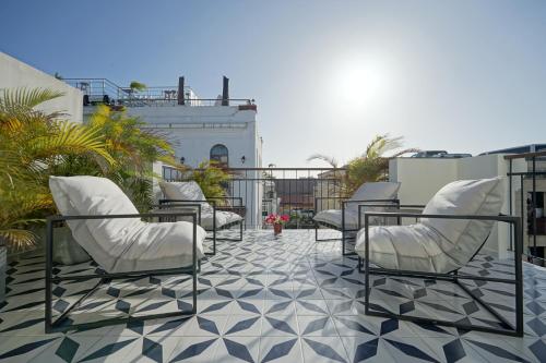 a patio with white chairs and a tile floor at Casa Contemporánea by Wynwood House in Panama City