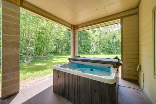 a hot tub on a screened in porch with a large window at Spacious House on Half Acre Less Than 3 Mi to Beach! in Sawyer