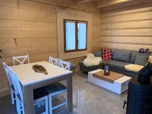 a living room with a table and a couch at Mountain View Chalet with HotTub and Sauna in Czerwienne