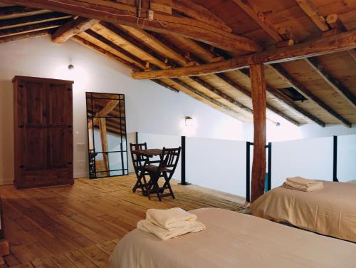 ein Zimmer mit 2 Betten und einem Stuhl darin in der Unterkunft La Cabaña del Risco in Ligos