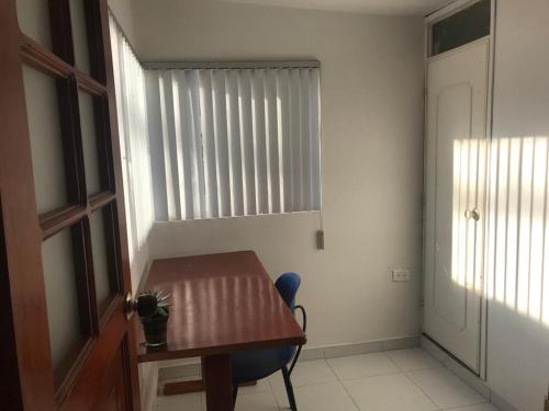 ein kleines Zimmer mit einem Holztisch und einem Fenster in der Unterkunft Apartamento Dúplex - Barrio Maldonado Tunja in Tunja