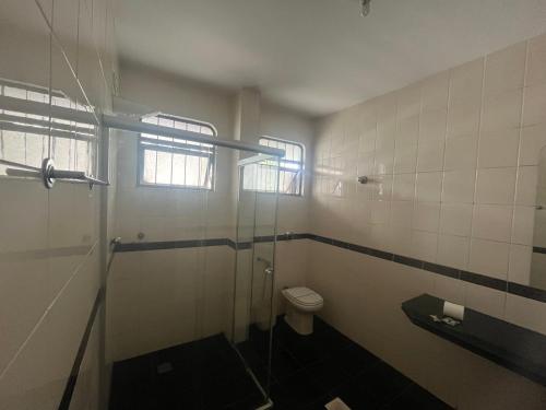 a bathroom with a toilet and a glass shower at Suíte completa no Bueno Somente para mulheres in Goiânia