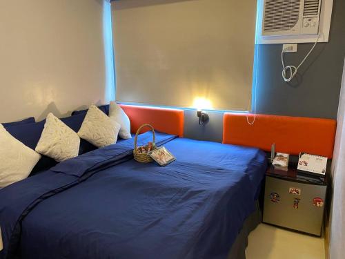 een slaapkamer met een blauw bed met een oranje hoofdeinde bij Nager Travellers Inn in Manilla