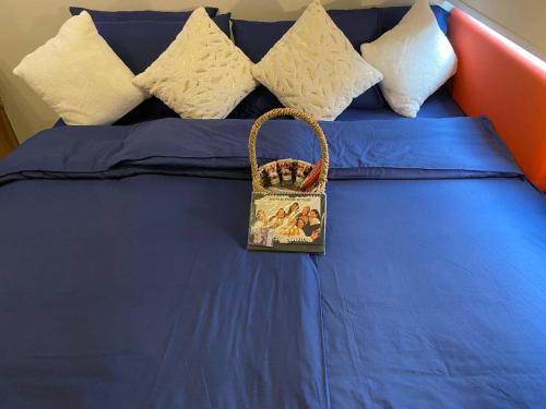 een tas op een blauw bed met kussens bij Nager Travellers Inn in Manilla