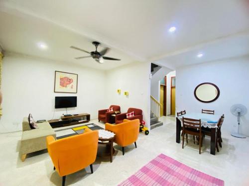 a living room with a couch and a table and chairs at HOMESTAY DSENJA in Kepala Batas