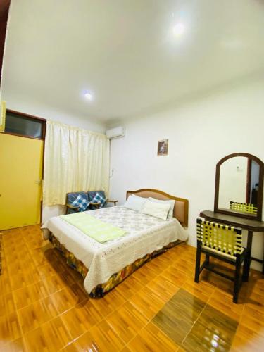 a bedroom with a bed and a mirror and a table at HOMESTAY DSENJA in Kepala Batas