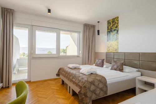 a bedroom with a bed and a large window at Rogač Rooms & Restaurant in Omiš
