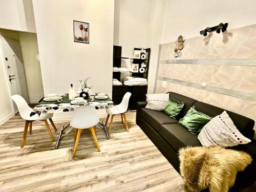 un salon avec un canapé noir et une table dans l'établissement Appartement 2pièces paris Disney, à Vaires-sur-Marne