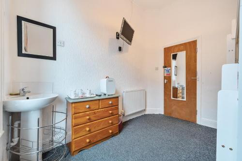 uma casa de banho com um lavatório e uma cómoda em madeira em Willin House Hotel em Blackpool