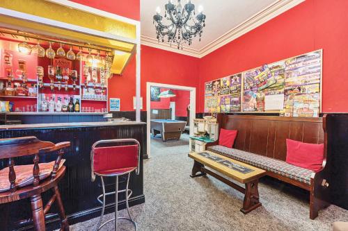 a bar with red walls and a bench in a room at Willin House Hotel in Blackpool