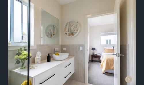 a bathroom with a sink and a mirror at Salt Zen Holiday Townhouse in Agnes Water