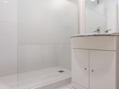 une salle de bain blanche avec une douche et un lavabo dans l'établissement Appartement Calme Proche Plage avec Terrasse Sud, Parking Sécurisé et Équipements Complets - FR-1-306-909, à Saint-Brévin-les-Pins