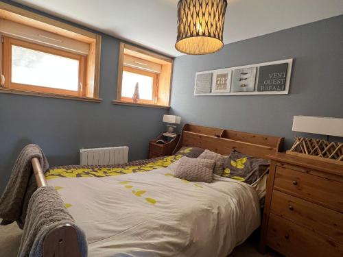 - une chambre avec un lit, une commode et des fenêtres dans l'établissement Appartement cosy à La Bresse avec terrasse, proche des pistes et équipements tout inclus - FR-1-589-407, à La Bresse
