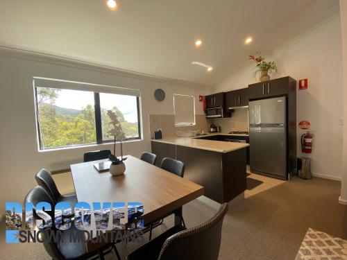 a kitchen and dining room with a table and chairs at Aspen Creek 3 in Thredbo