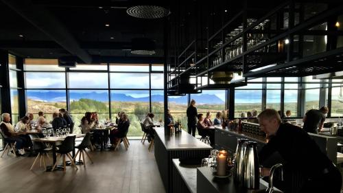 um grupo de pessoas sentadas em mesas em um restaurante em Hotel Varmaland em Varmaland