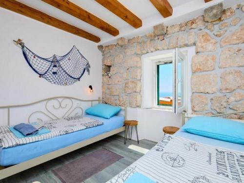 a bedroom with two beds and a stone wall at Holiday house with a parking space Babino Polje, Mljet - 22324 in Babino Polje