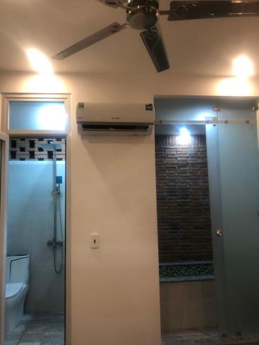 a bathroom with a toilet and a ceiling fan at miniHomestay green view - single room - Ea Kar - Dak Lak in Buôn Mhang