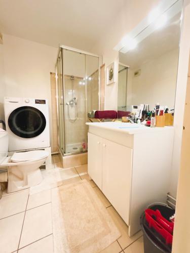 uma casa de banho com um chuveiro, um WC e um lavatório. em Très jolie F2 cosy 45m2 avec balcon et parking proche Paris em Livry-Gargan