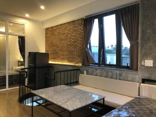 ein Wohnzimmer mit einem Sofa und einem Tisch in der Unterkunft miniHomestay green view - single room - AC and bathtub - Ea Kar - Dak Lak in Buôn Mhang