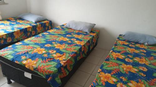 two beds sitting next to each other in a room at Pousada Family in Salvador