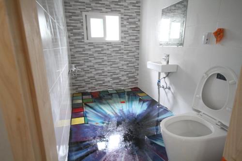 a bathroom with a floor that has a colorful floor at Time Travelers Party Hostel In Hongdae in Seoul