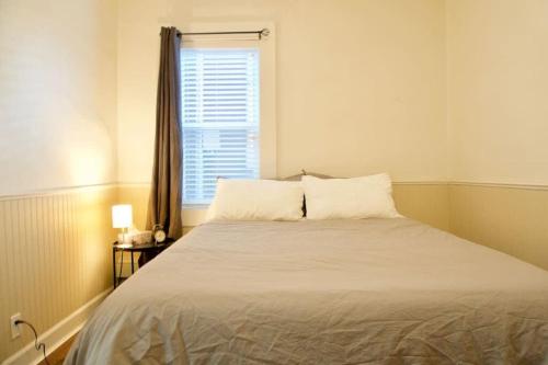 a bedroom with a large bed with a window at NEW Downtown MJ Parking Near Tunnels, Casino & Spa Coffee in Moose Jaw