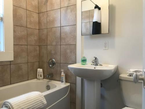 a bathroom with a sink and a toilet and a tub and a sink at NEW Downtown MJ Parking Near Tunnels, Casino & Spa Coffee in Moose Jaw
