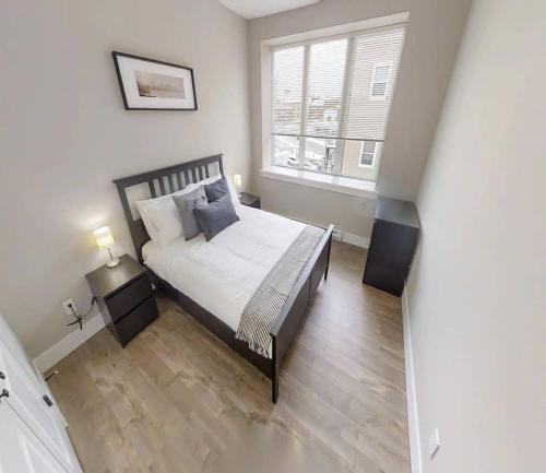 ein Schlafzimmer mit einem Bett und einem großen Fenster in der Unterkunft Premium Condo Heart of Uptown Location Parking Coffee in Saint John