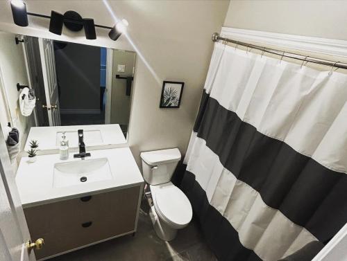 a bathroom with a white toilet and a sink at Premium 2-bed Condo Uptown Saint John Parking Coffee Location in Saint John